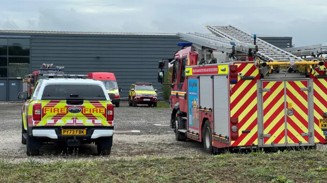 Fire service vehicles outside a large grey building