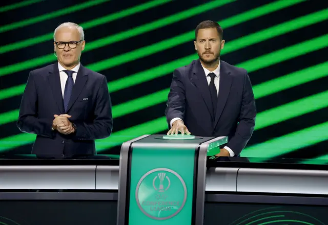 Former Chelsea player Eden Hazard (R), standing next to UEFA Deputy General Secretary Giorgio Marchetti, pushes the button to initiate the automated draw for the UEFA Conference League during UEFA Europa League and UEFA Conference League Group league phase draws at the Grimaldi Forum in Monaco, 29 August 2025.