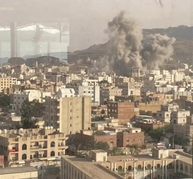A large plume of smoking rising from a city