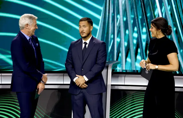 Draw hosts Matt Smith (L) and Becky Ives (R) speak with former Chelsea player Eden Hazard before the UEFA Conference League draw during UEFA Europa League and UEFA Conference League Group league phase draws at the Grimaldi Forum in Monaco, 29 August 2025.