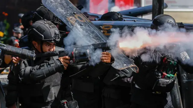 Riot police firing tear gas