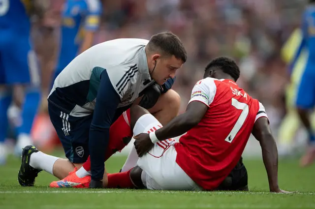 Bukayo Saka holding his hamstring