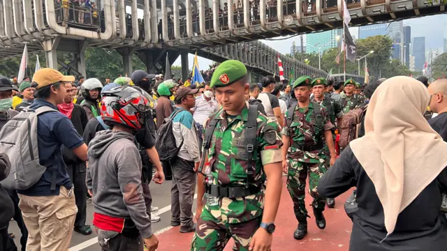Man in military uniform waling through crowds of people