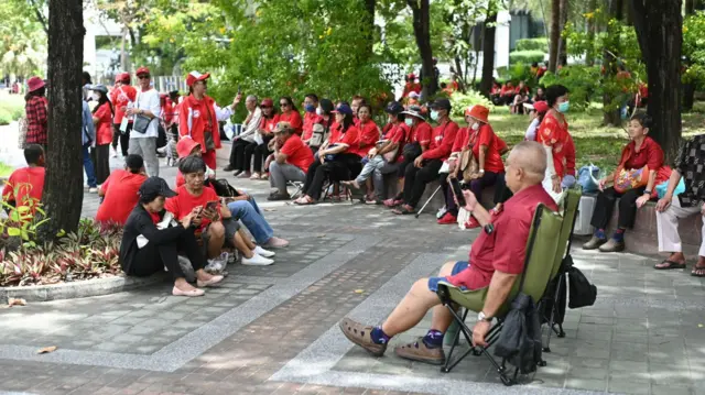 red shirt supporters waiting outside on the ground