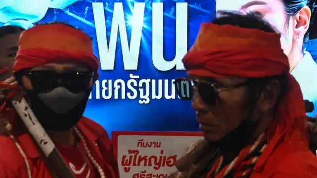 Two people wearing sunglasses and red head scarves