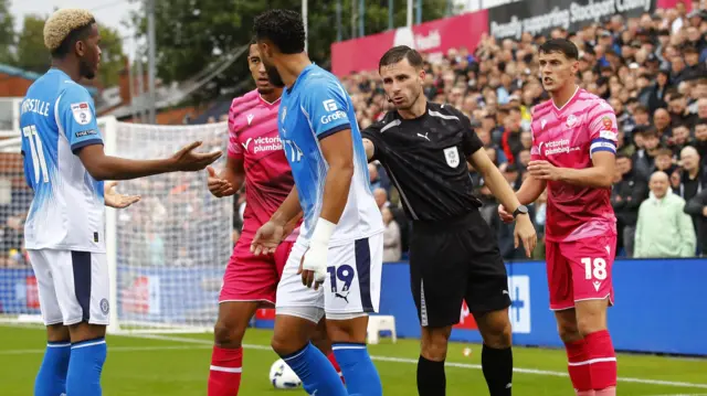 Referee Elliot Bell calms the situation