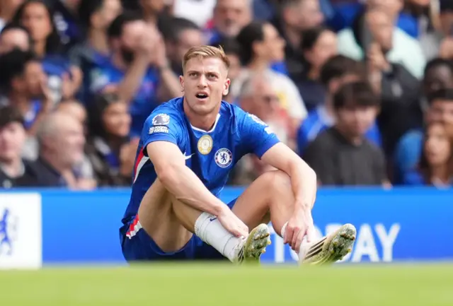 Chelsea's Liam Delap waits for treatment after pulling up with an injury
