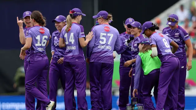 Kate Cross celebrates with her teammates after taking the wicket of Kira Chathli