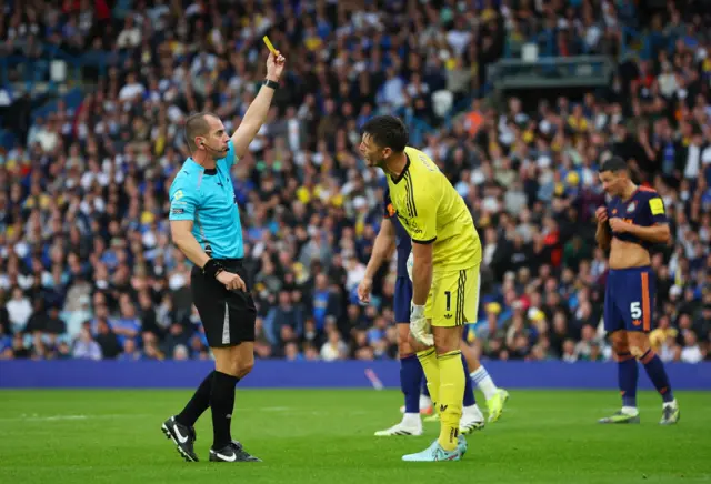 Newcastle United's Nick Pope is shown a yellow card by referee Peter Bankes
