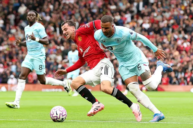 Mason Mount of Manchester United is challenged by Kyle Walker of Burnley during the Premier League match between Manchester United and Burnley at Old Trafford on August 30, 2025 in Manchester, England.
