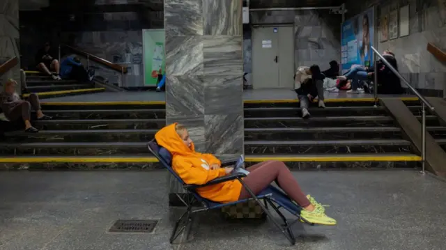 People take shelter in a metro station during a Russian drone attack on Ukraine