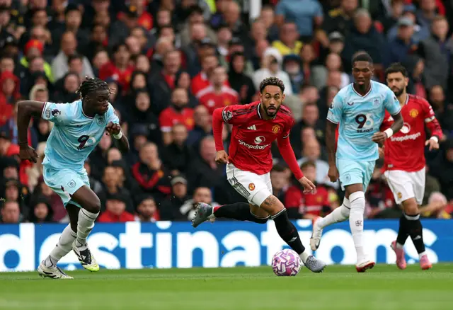 Matheus Cunha of Manchester United runs ahead of Lesley Ugochukwu of Burnley during the Premier League match between Manchester United and Burnley at Old Trafford