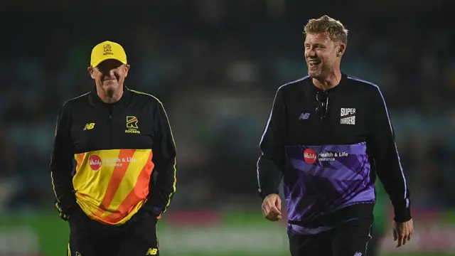 Andy Flower and Andrew Flintoff leave the field after talking with the umpires