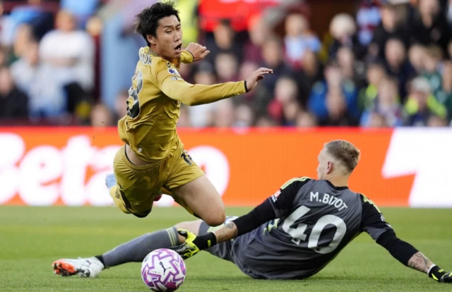 Crystal Palace's Daichi Kamada (left) is fouled by Aston Villa goalkeeper Marco Bizot