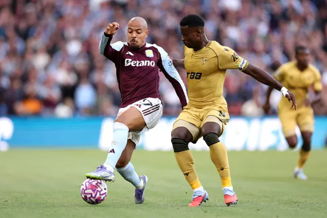 Donyell Malen of Aston Villa controls the ball whilst under pressure from Marc Guehi