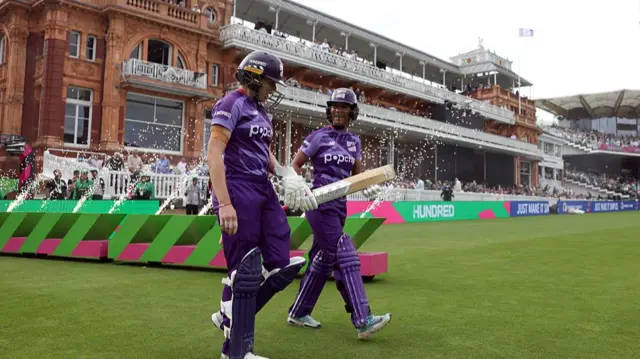 Davina Perrin of Northern Superchargers walks out to bat alongside team mate Alice Davidson-Richards