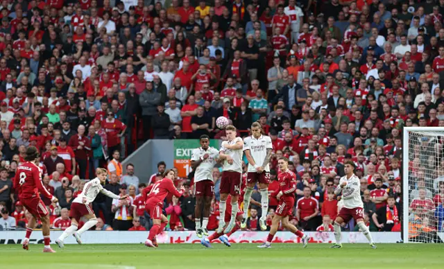 Dominik Szoboszlai (L) strikes the ball over the wall from a free kick