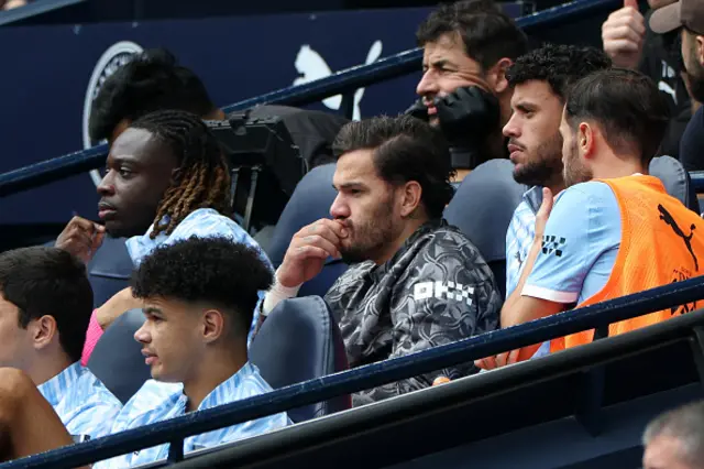 Ederson (C) sits on the bench