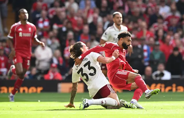 Mohamed Salah of Liverpool is challenged by Riccardo Calafiori