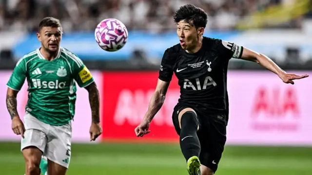 Son Heung-min eyes the ball as Newcastle United's Kieran Trippier watches