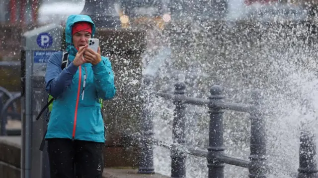 A person takes pictures with their phone at the esplanade