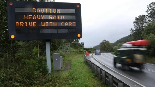 A board displays a warning sign for drivers, as Storm Floris hits Scotland