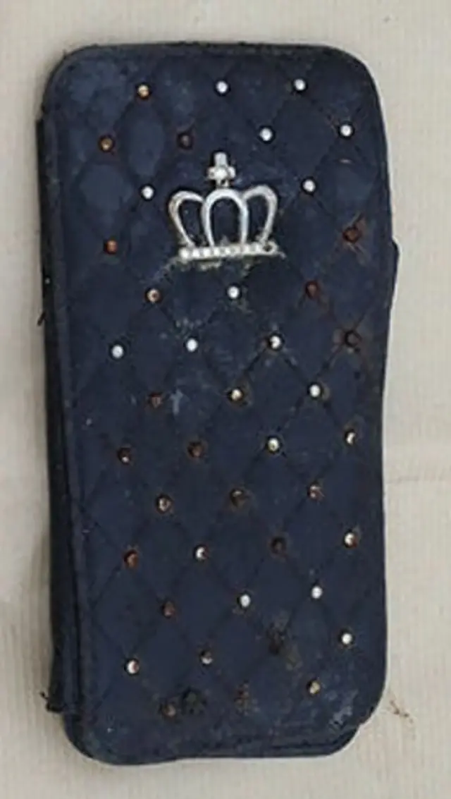 A black quilted phone case with studs and a crown on the front