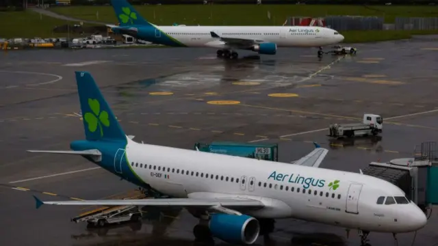 Two Aer Lingus planes wait on the wet tarmac at Dublin airport
