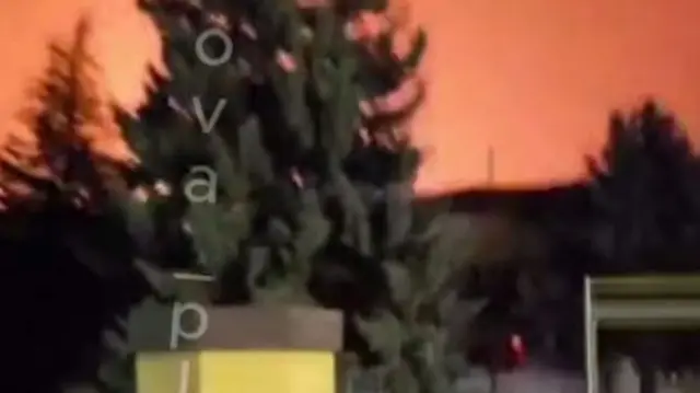 A screengrab from the video shows the night sky glowing red from an explosion