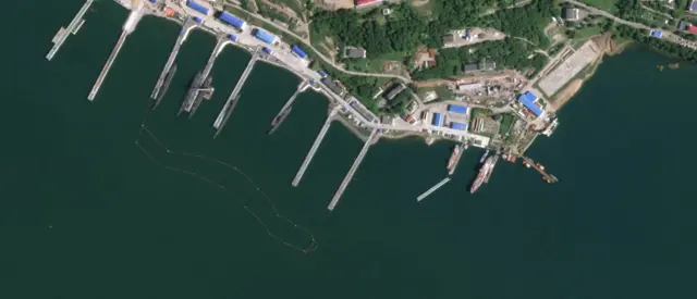 Satellite image from Planet Labs over Rybachiy submarine base, far eastern Russia. It shows 11 piers, one of which has snapped about halfway along, with half of it free in the water.