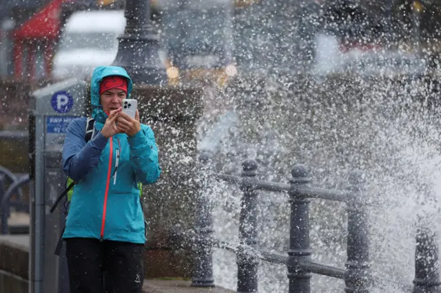 person in storm holding a phone
