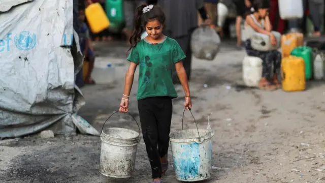 A Palestinian girl carries buckets of water