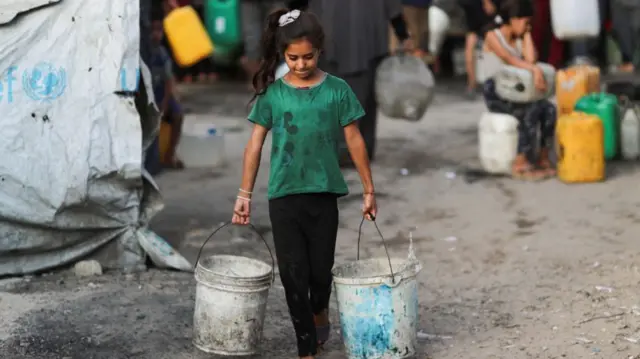 A Palestinian girl carries buckets of water amid shortages, in Gaza City August 6, 2025.