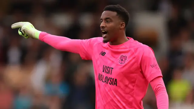 Nathan Trott holds his right arm out to the side as he shouts to a team-mate