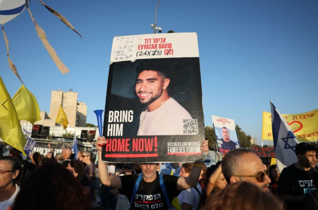 One demonstrator holds up a placard with the photo of Evyatar David with his current age 24 and the age he was in when he was kidnapped in 2023