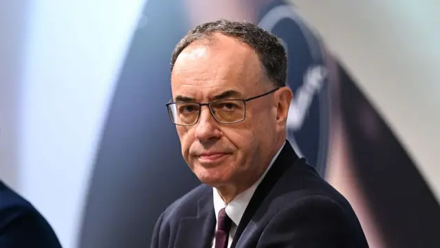 Close up of BoE Governor Andrew Bailey sitting down in a dark suit, white shirt and burgundy tie