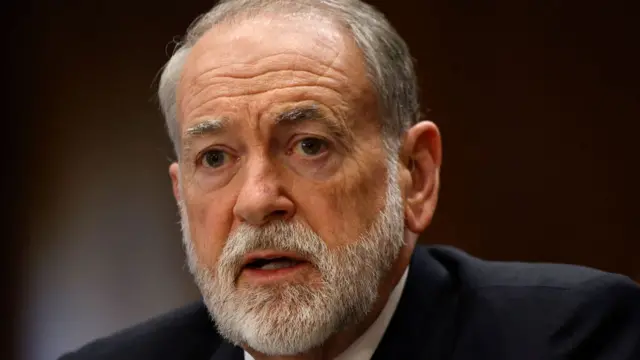 Headshot of Huckabee talking. It's very zoomed in and you can't see anything in the blurred background. he has grey facial hair and hair