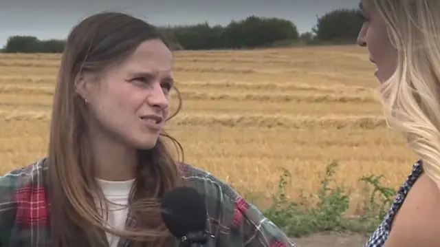 Gabrielle Aplin is interviewed by a journalist in a field.