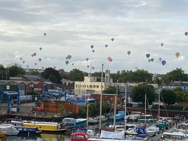 Balloons flying with the harbour in the foreground