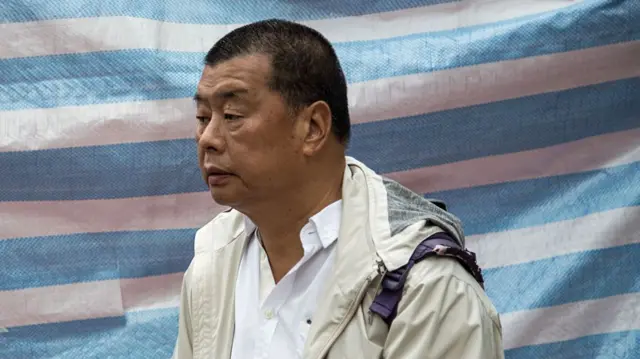 Side view of Jimmy Lai in a white jacket