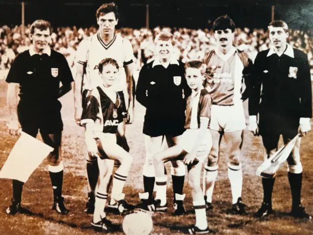 An old photo of young mascots with captains and officials at a West Ham game