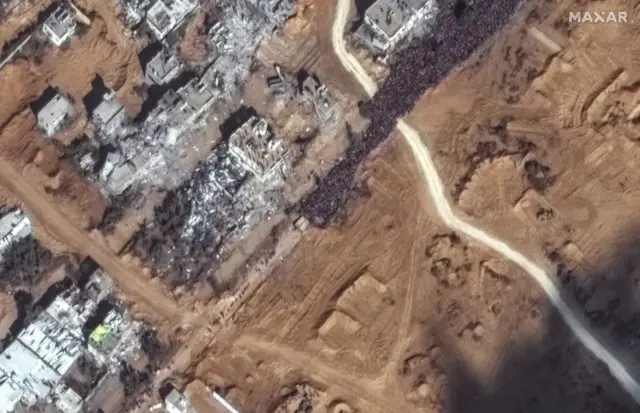 Maxar closeup satellite imagery shows a large crowd of people gathered along Salah al Deen Road in southern Gaza attempting to flee south along the evacuation corridor