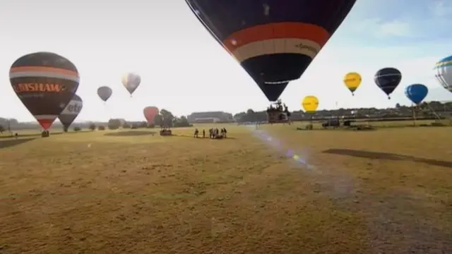 Hot air balloons landing on a grassy field