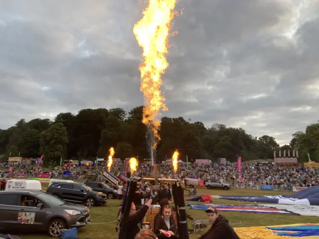 A balloon basket with flames from the burner coming from the top