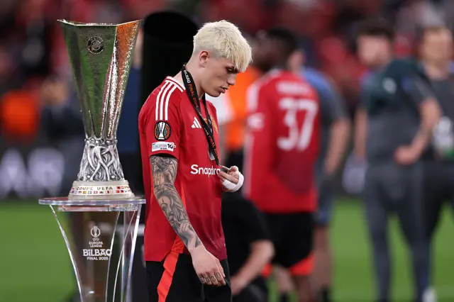 Alejandro Garnacho of Manchester United walks past the UEFA Europa League trophy
