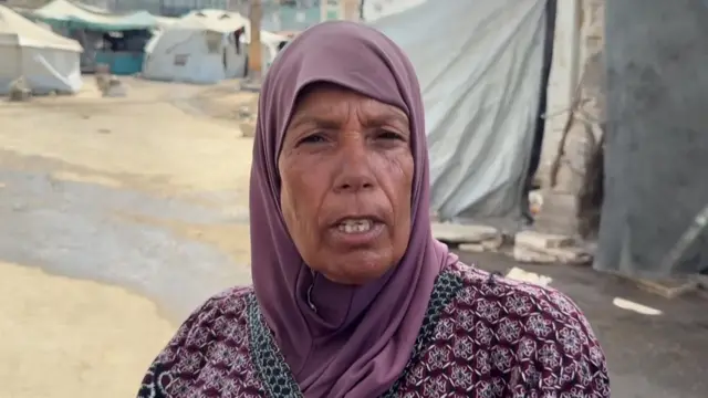Maghzouza Saada speaks outside several tents in Gaza City