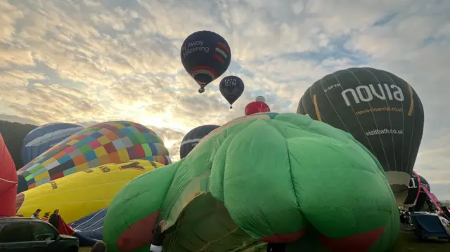 Balloons are slowly being inflated with hot air ready to take off