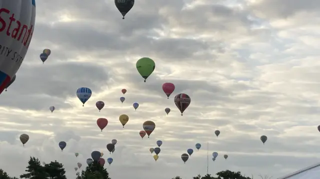Many balloons in the sky scattered all over.