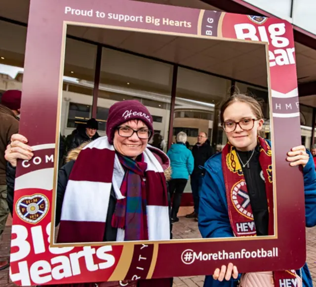 Two women hold up Hearts sign
