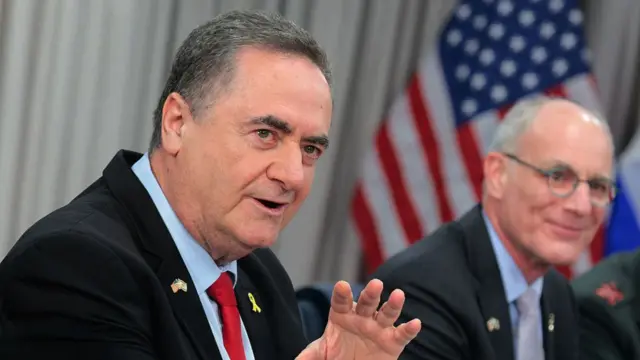 Israeli Defence Minister Israel Katz (L) sits next to Israeli Ambassador to the U.S. Yechiel Leiter during a meeting with his counterpart Pete Hegseth in Virginia. Behind the pair is a US flag, blurred